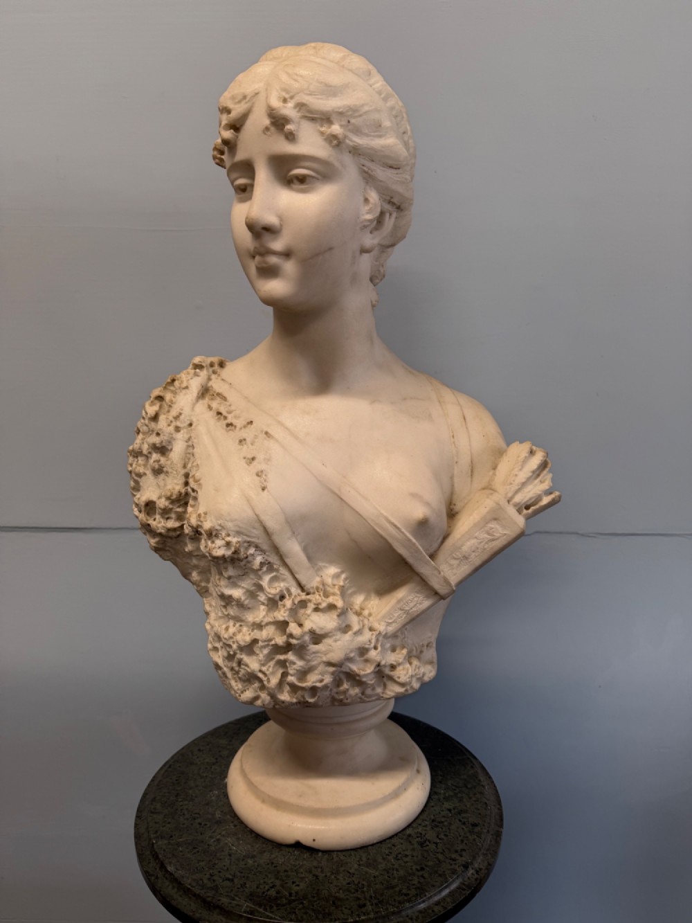 Carved white marble bust depicting Diana the Huntress with a quiver over her shoulder resting on a round moulded base. View VI