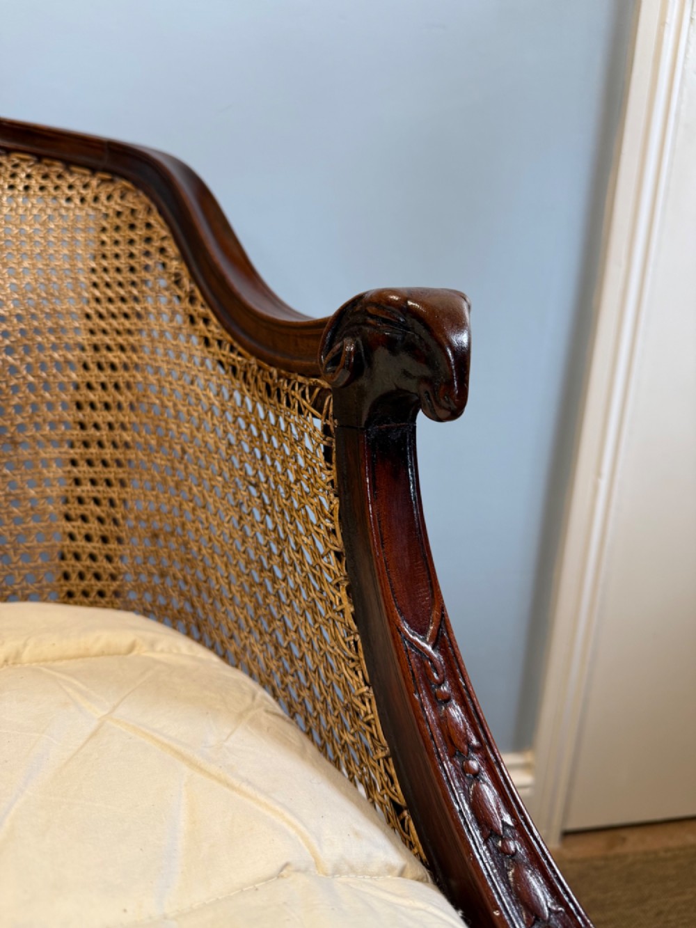 An antique mahogany bergere armchair featuring hand-woven cane panels, a curved backrest, fluted seat rail, and turned front legs. View IV