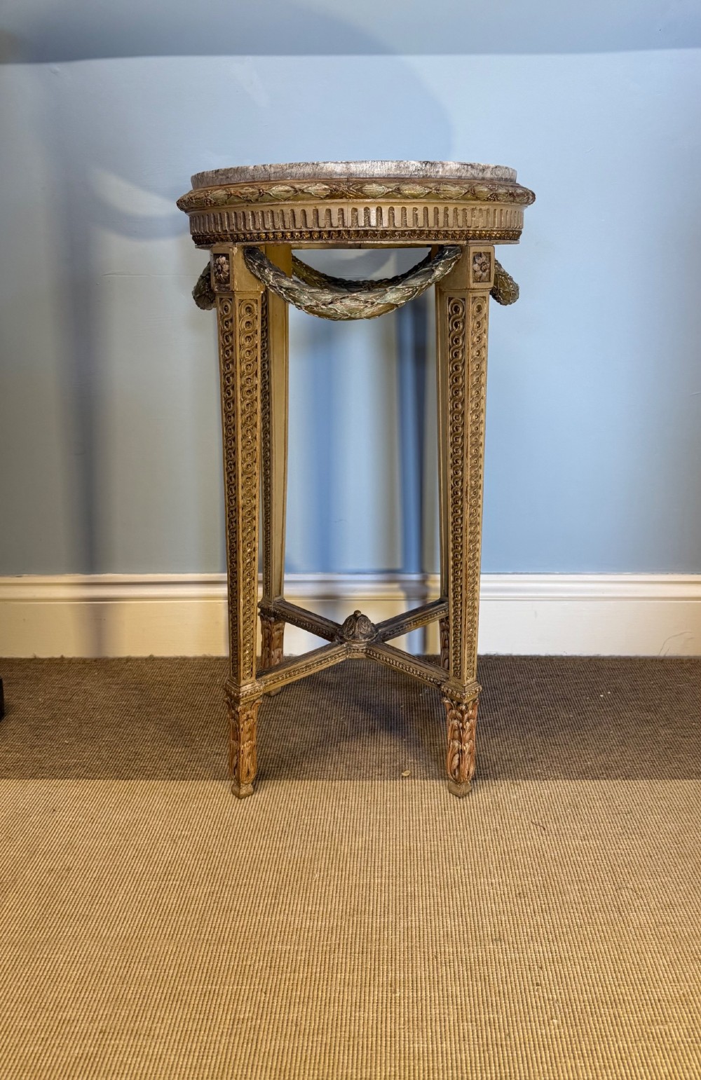 A tall 19th-century French Neoclassical style plant stand featuring a circular grey marble top, carved cream and parcel-gilded legs with swags, and a central X-stretcher.