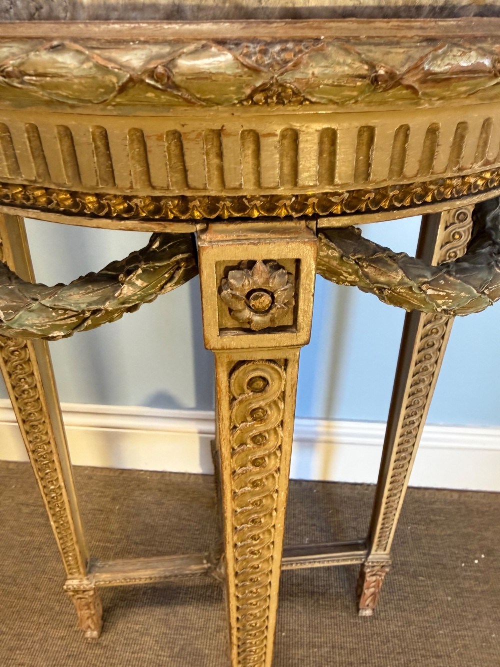 A tall 19th-century French Neoclassical style plant stand featuring a circular grey marble top, carved cream and parcel-gilded legs with swags, and a central X-stretcher. View VI