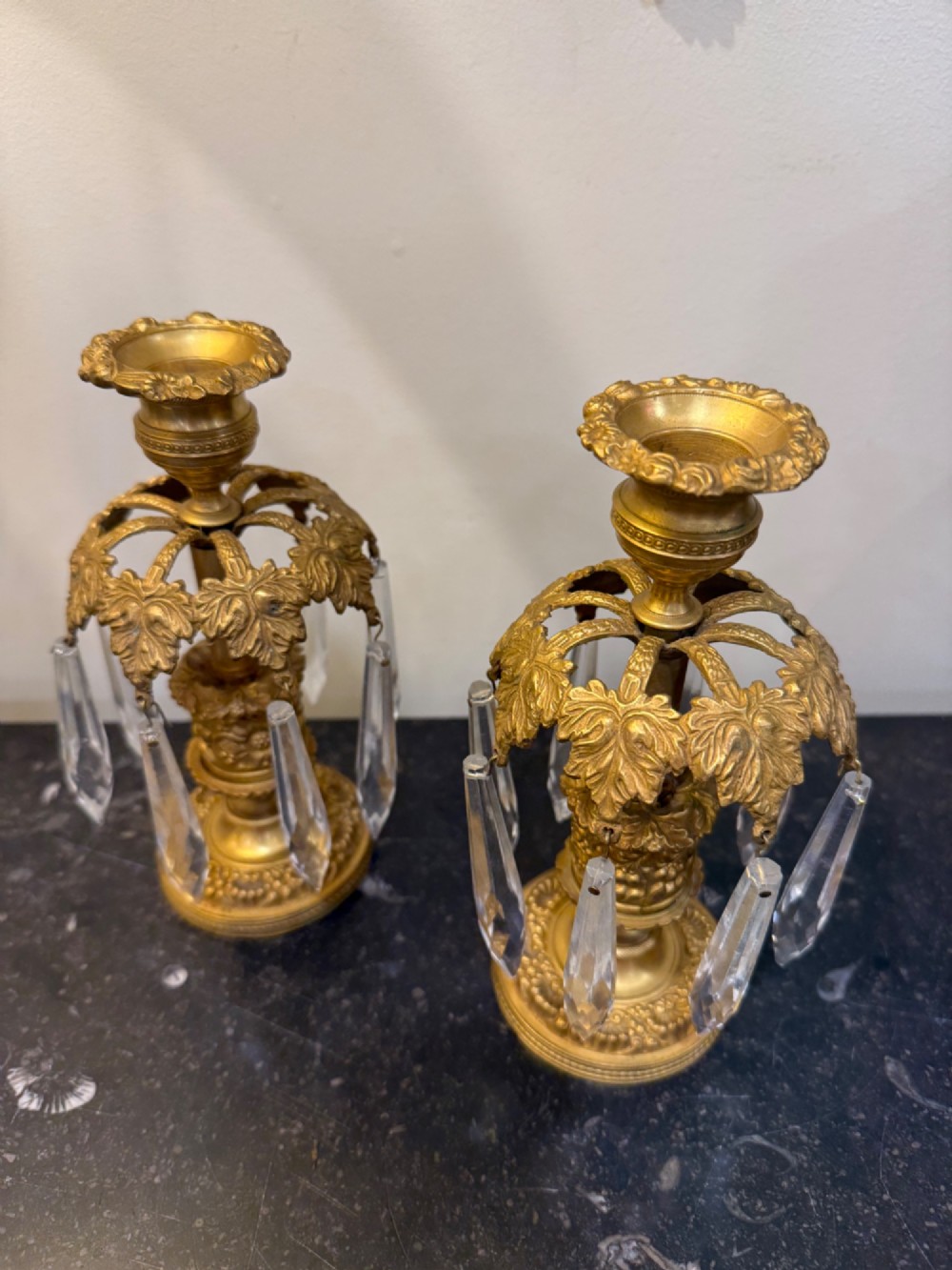 A pair of 19th-century gilt bronze ormolu candlesticks featuring acanthus leaf crowns and suspended clear crystal prism lustres. View II