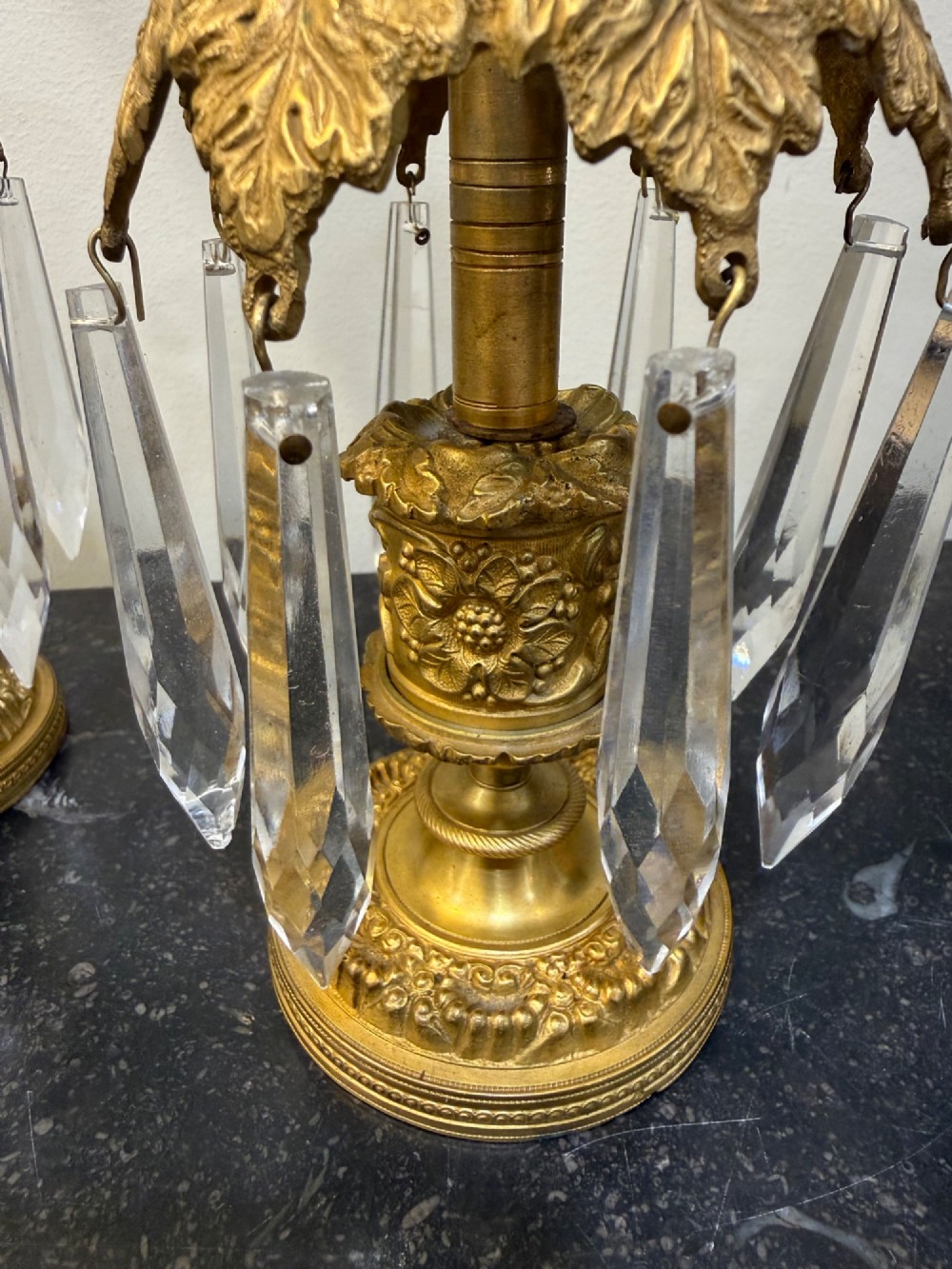 A pair of 19th-century gilt bronze ormolu candlesticks featuring acanthus leaf crowns and suspended clear crystal prism lustres. View IV
