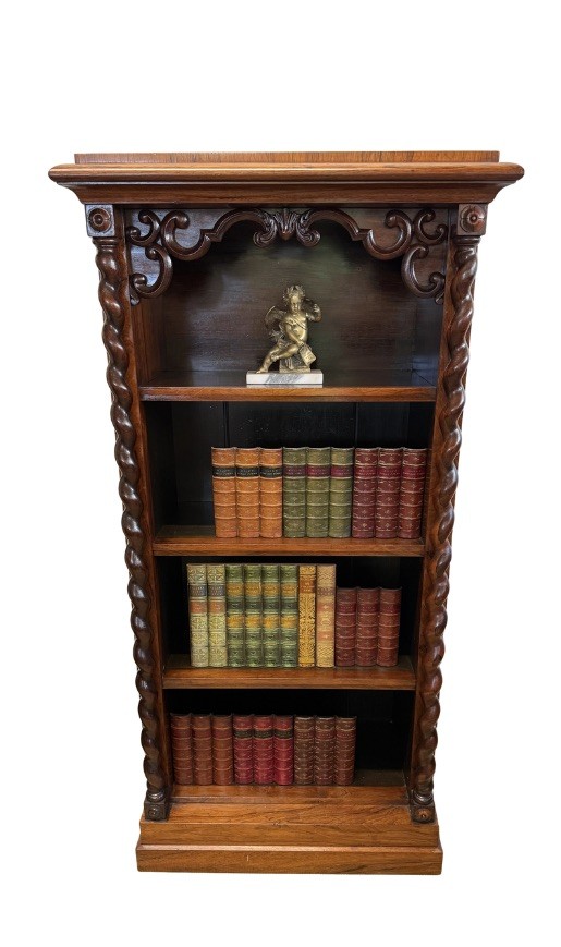 A 19th-century Victorian rosewood open bookcase featuring four open shelves flanked by barley twist pilasters and topped with carved scrollwork.