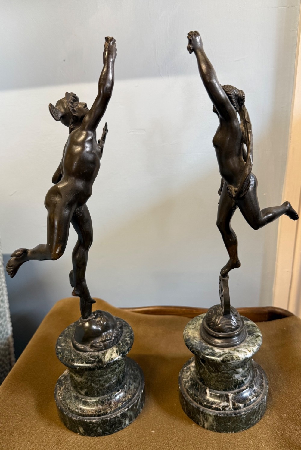 A pair of dark bronze Neoclassical figures depicting Mercury and Fortuna mounted on cylindrical green marble pedestals. View IV