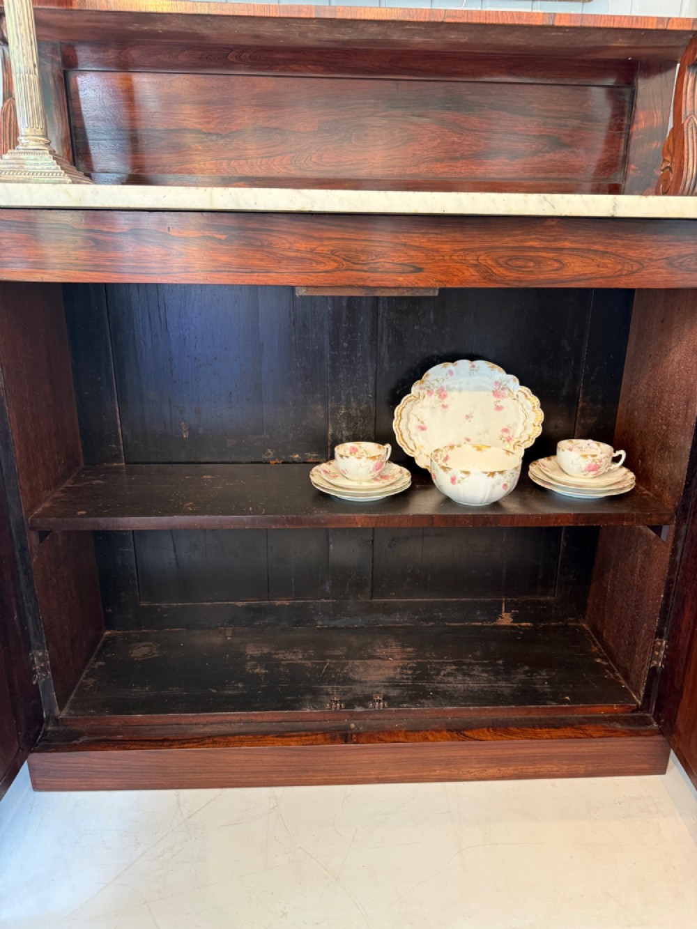 A nineteenth-century dark rosewood chiffonier featuring a white marble top surface, twin mirrored door panels, and a raised upper shelf with brass gallery detailing. View V