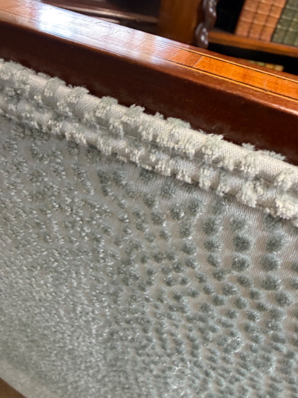 An Edwardian two-seater mahogany sofa upholstered in light blue damask fabric with satinwood crossbanding along the frame. View V