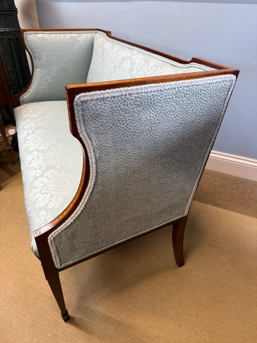 An Edwardian two-seater mahogany sofa upholstered in light blue damask fabric with satinwood crossbanding along the frame. View VI