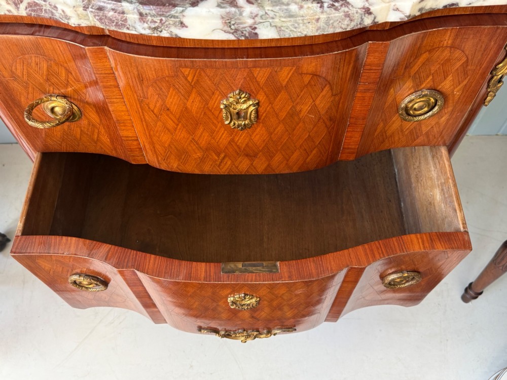 A mid 19th-century French commode featuring a marble top, parquetry wood veneer, two drawers with gilt bronze handles, and cabriole legs. View X