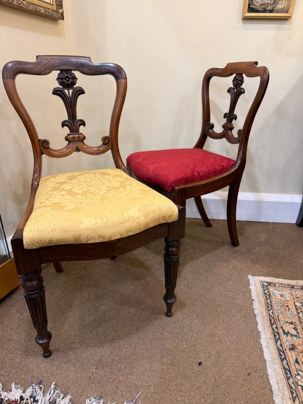 A set of four Victorian rosewood balloon-back dining chairs with carved centre splats and individual damask upholstered seats in yellow, red, cream, and blue. View V