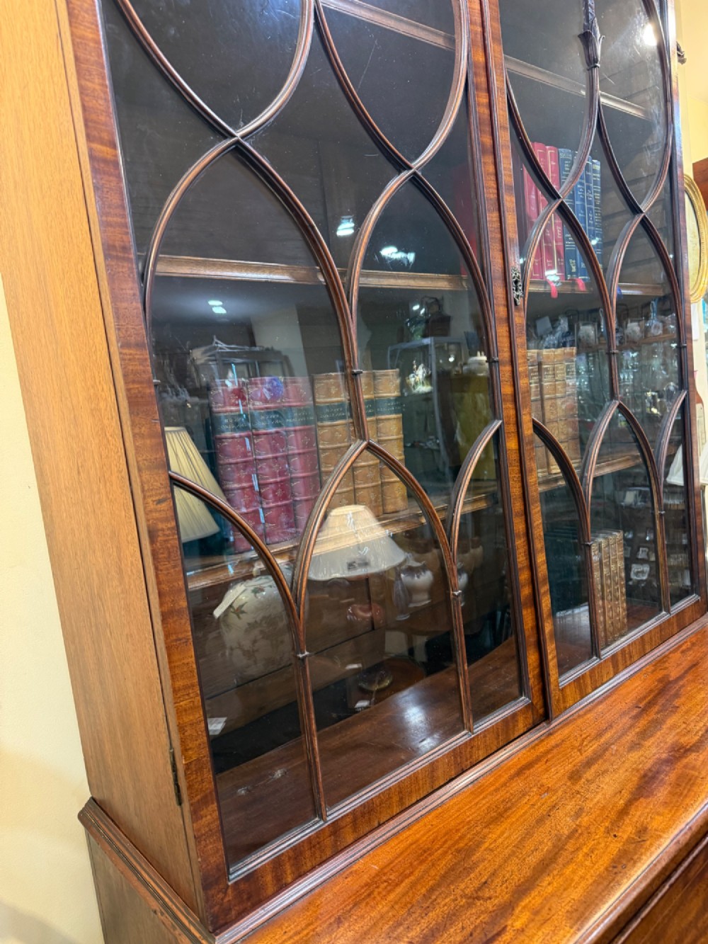 An 18th-century mahogany secretaire bookcase featuring a swan-neck pediment, astragal glazed upper doors, and a fall-front drawer above double doors. View V