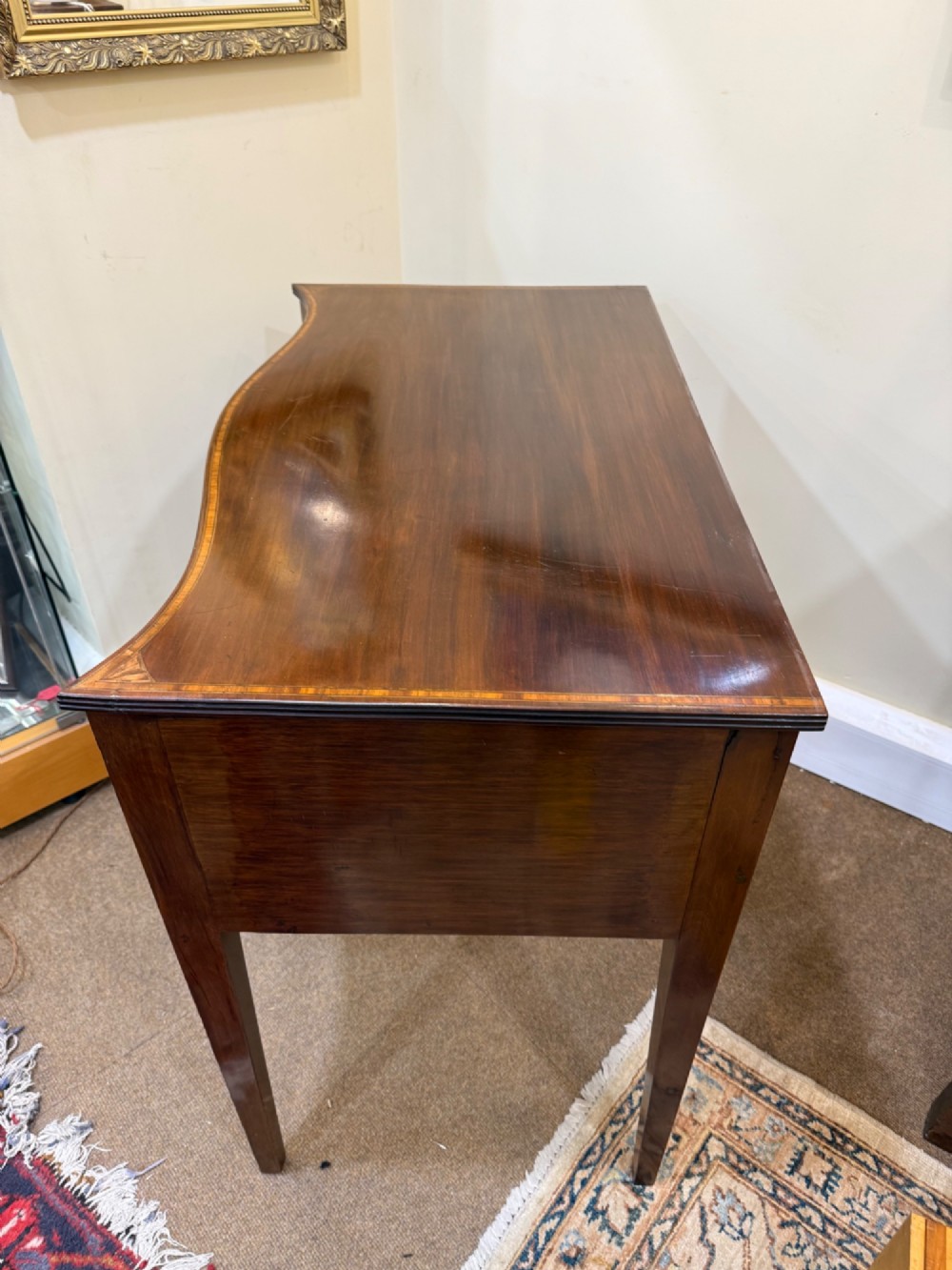 An Edwardian mahogany side cabinet featuring satinwood inlay, brass ring handles, three drawers, and square tapered legs. View VI