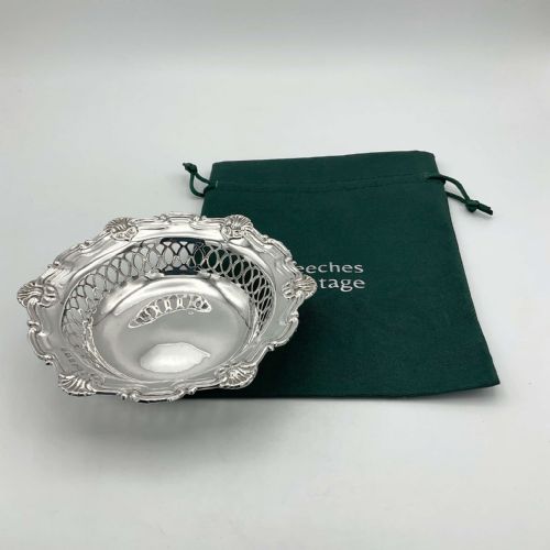 fig 1. A circular Edwardian sterling silver bon bon dish featuring intricate pierced lattice sides and a scalloped shell-motif rim.