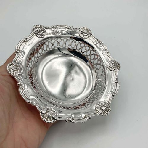 fig 2. A circular Edwardian sterling silver bon bon dish featuring intricate pierced lattice sides and a scalloped shell-motif rim.