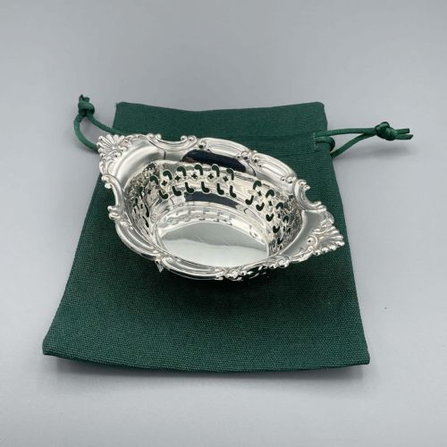 fig 1. An oval sterling silver dish featuring reticulated openwork sides and a molded scrollwork rim.