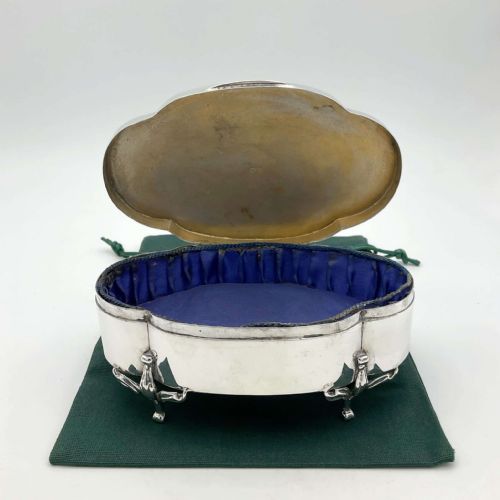 fig 1. An oval 1918 sterling silver jewellery box featuring scrolled cabriole legs and an engraved monogram on the hinged lid.