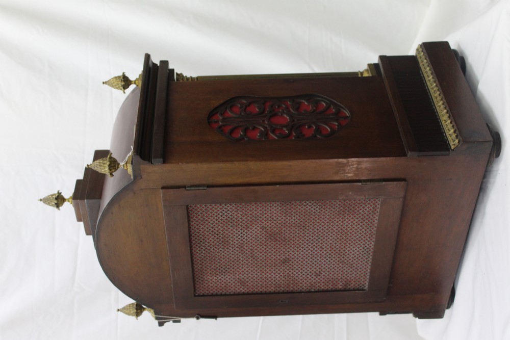 A dark mahogany Edwardian bracket clock featuring brass column supports, pineapple finials, and an ornate silvered dial with subsidiary chime indicators. View III