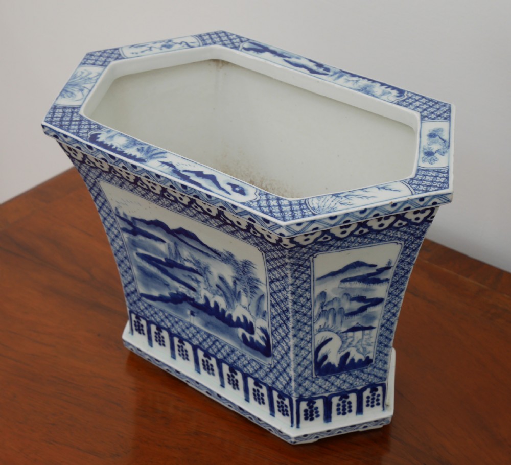 A rectangular blue and white ceramic jardiniere decorated with painted Chinese landscape panels and geometric lattice borders. View II