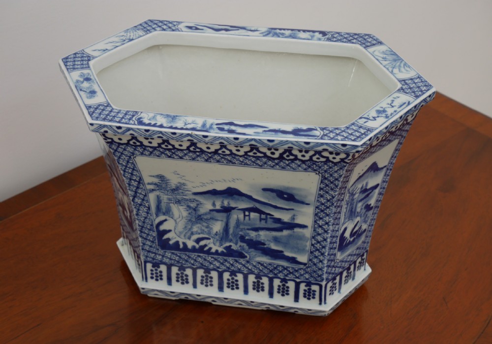 A rectangular blue and white ceramic jardiniere decorated with painted Chinese landscape panels and geometric lattice borders. View III