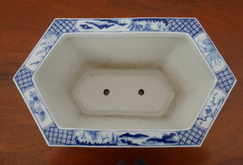 A rectangular blue and white ceramic jardiniere decorated with painted Chinese landscape panels and geometric lattice borders. View IV