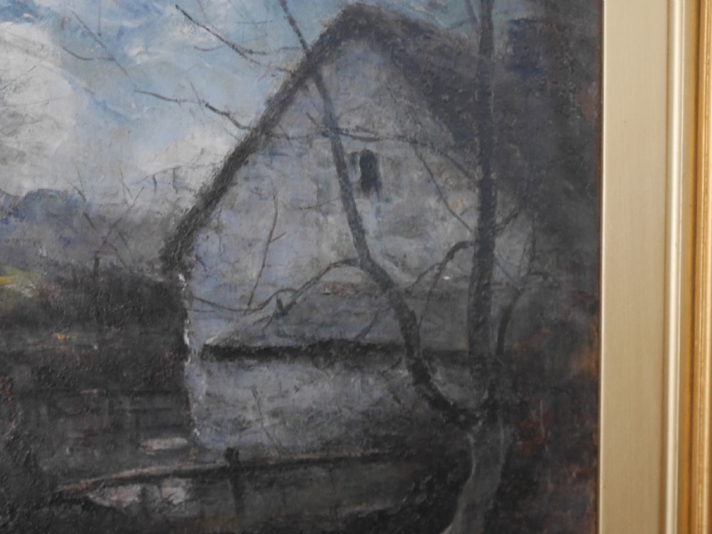 A framed oil painting depicting a rural cottage alongside a small stream beneath a cloudy blue sky, housed in a wide gilt frame. View IV