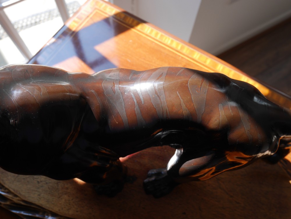 A dark bronze Japanese tiger sculpture depicted in a roaring, prowling stance mounted on a carved wooden base. View IV