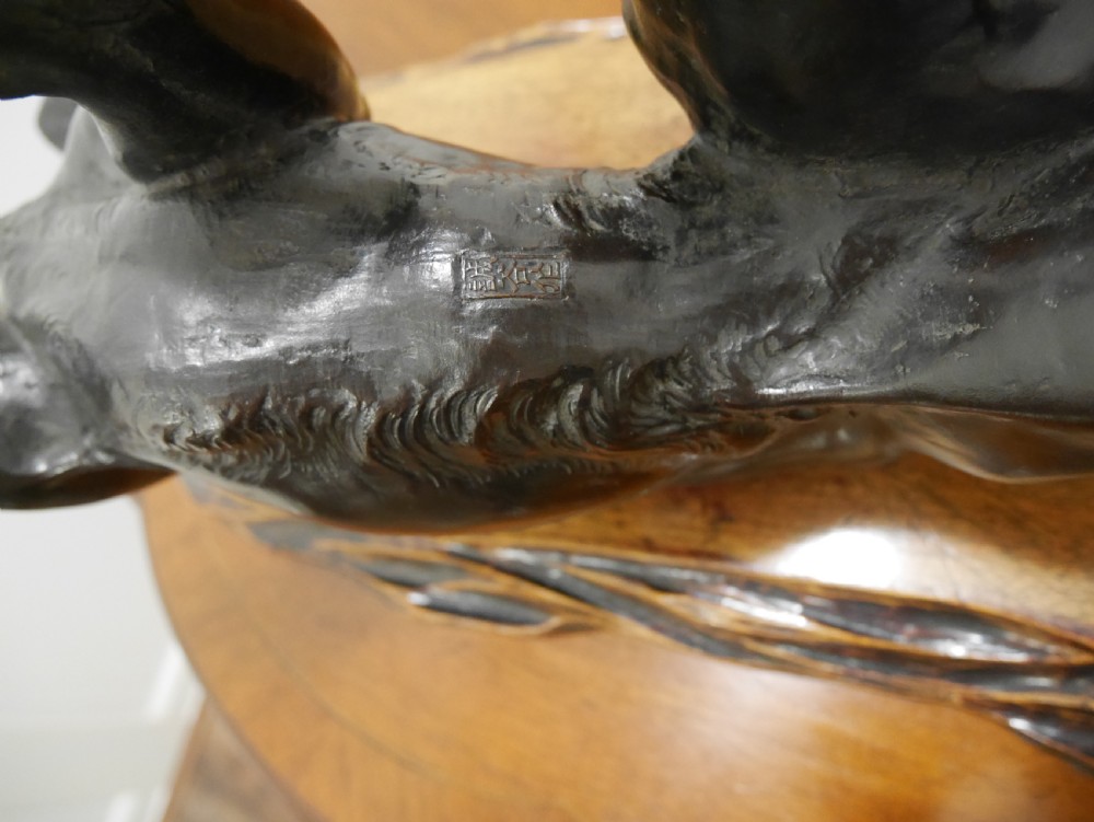 A dark bronze Japanese tiger sculpture depicted in a roaring, prowling stance mounted on a carved wooden base. View VI