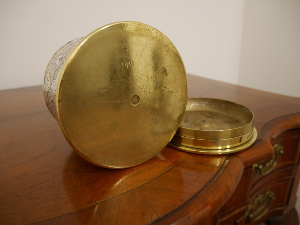 A cylindrical brass artillery shell casing converted into a lidded container with silver and copper Middle Eastern calligraphy inlays. View V