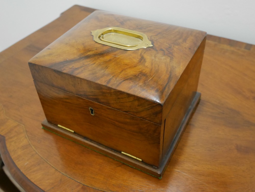 An open Victorian walnut dressing box featuring a blue button-tufted lining, three cut glass scent bottles, and brass hardware. View II