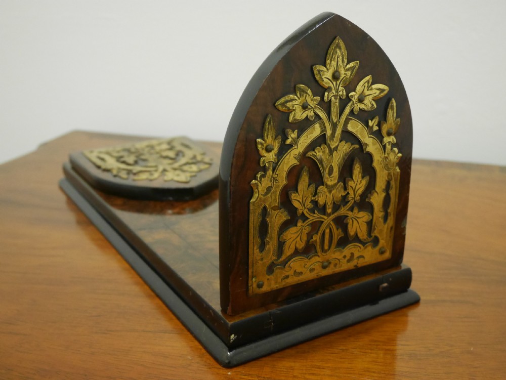 A nineteenth-century walnut book slide shown folded flat, decorated with pierced brass foliate strapwork on the hinged end panels. View IV