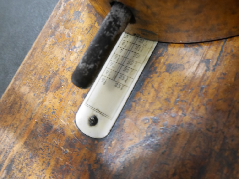 An antique wooden hat stretcher featuring a split crown block mounted on a flat wooden base with a metal threaded screw handle mechanism. View III