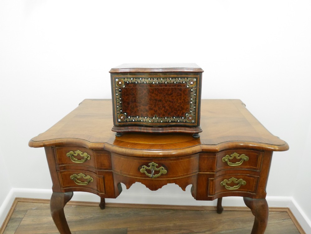 A French serpentine-front thuya wood box featuring foliate marquetry inlay, mother-of-pearl accents, a brass keyhole, and small turned feet. View II