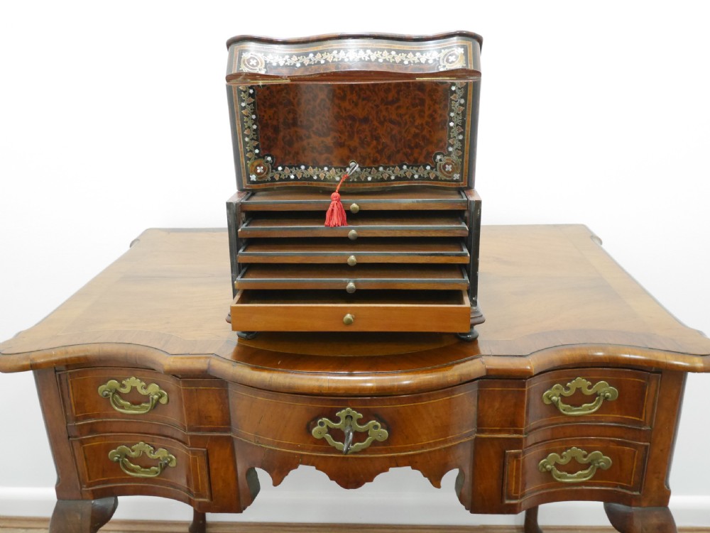 A French serpentine-front thuya wood box featuring foliate marquetry inlay, mother-of-pearl accents, a brass keyhole, and small turned feet. View III