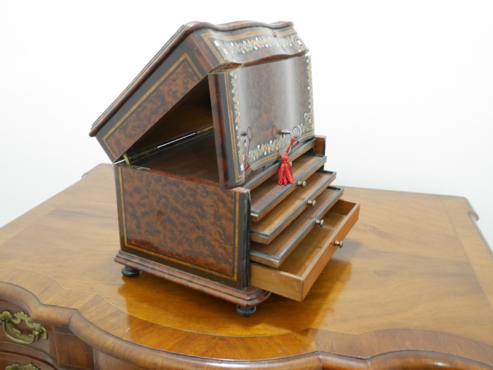 A French serpentine-front thuya wood box featuring foliate marquetry inlay, mother-of-pearl accents, a brass keyhole, and small turned feet. View V