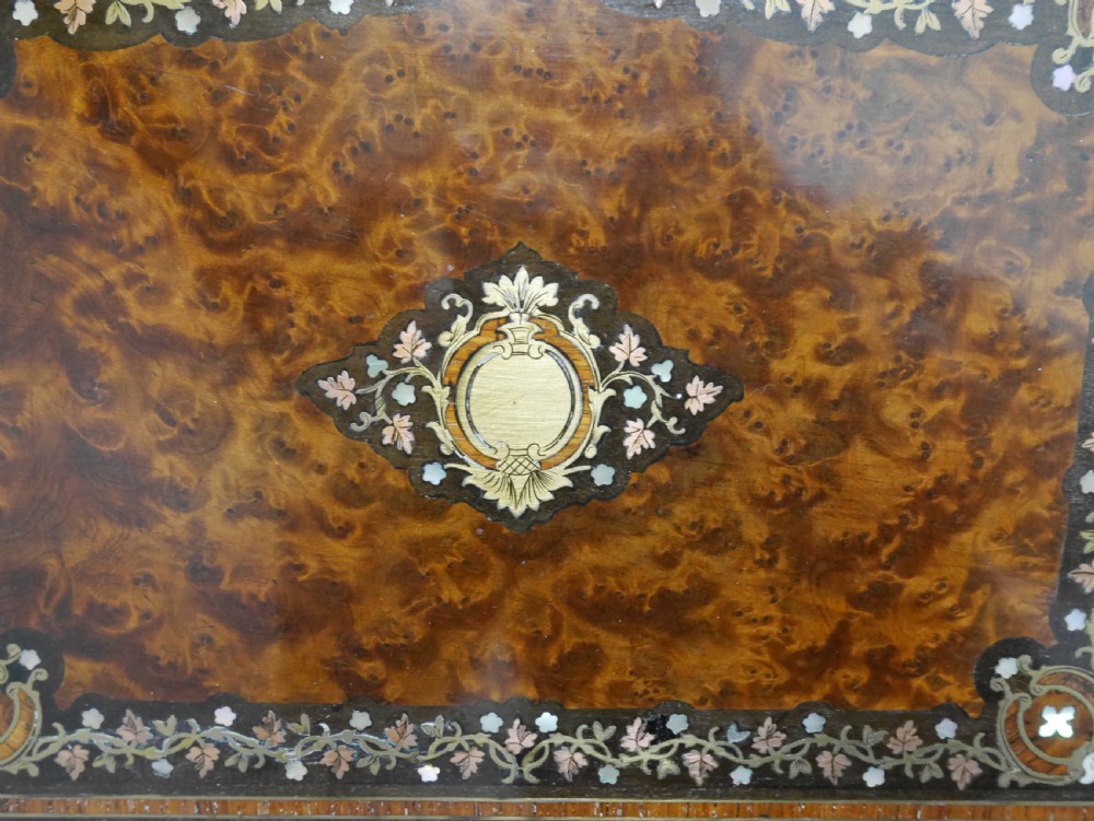 A French serpentine-front thuya wood box featuring foliate marquetry inlay, mother-of-pearl accents, a brass keyhole, and small turned feet. View VI