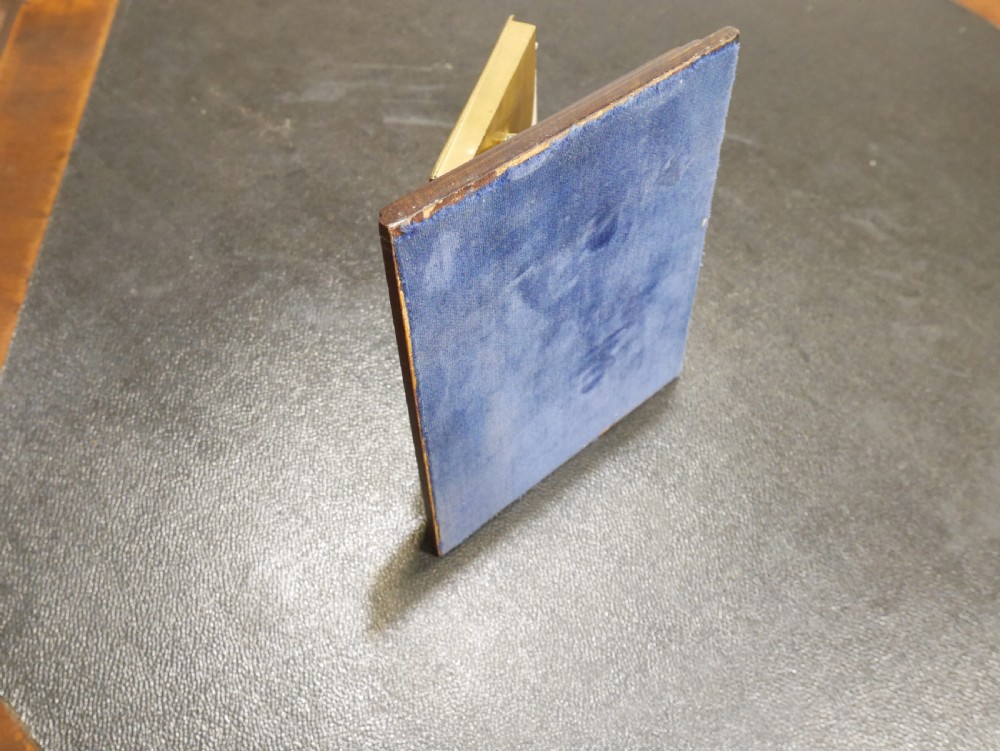 A vintage perpetual desk calendar with a polished brass frame holding paper month cards, mounted on a dark mahogany wooden base. View VI