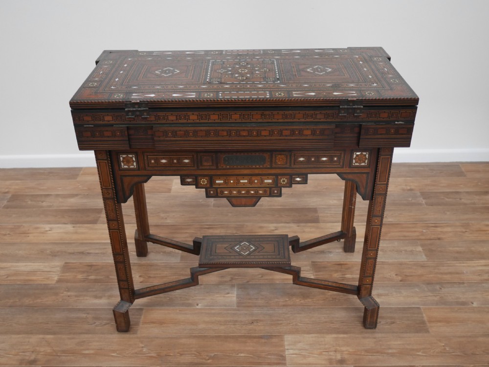 An antique rectangular Syrian games table featuring geometric micro-mosaic wood and mother-of-pearl inlays, turned drawers, and an intricate lower stretcher frame. View IV