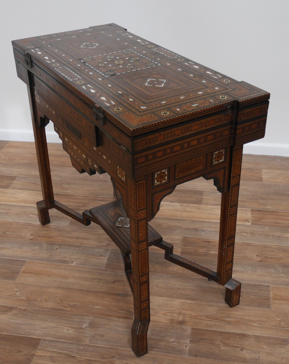 An antique rectangular Syrian games table featuring geometric micro-mosaic wood and mother-of-pearl inlays, turned drawers, and an intricate lower stretcher frame. View V