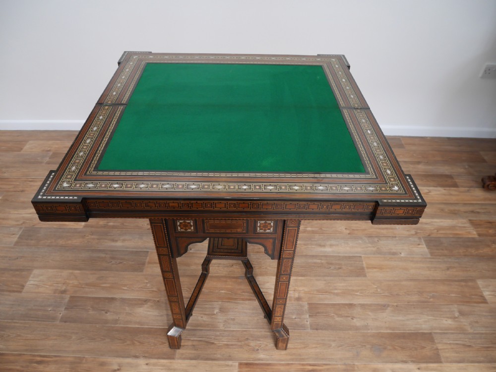 An antique rectangular Syrian games table featuring geometric micro-mosaic wood and mother-of-pearl inlays, turned drawers, and an intricate lower stretcher frame. View IX