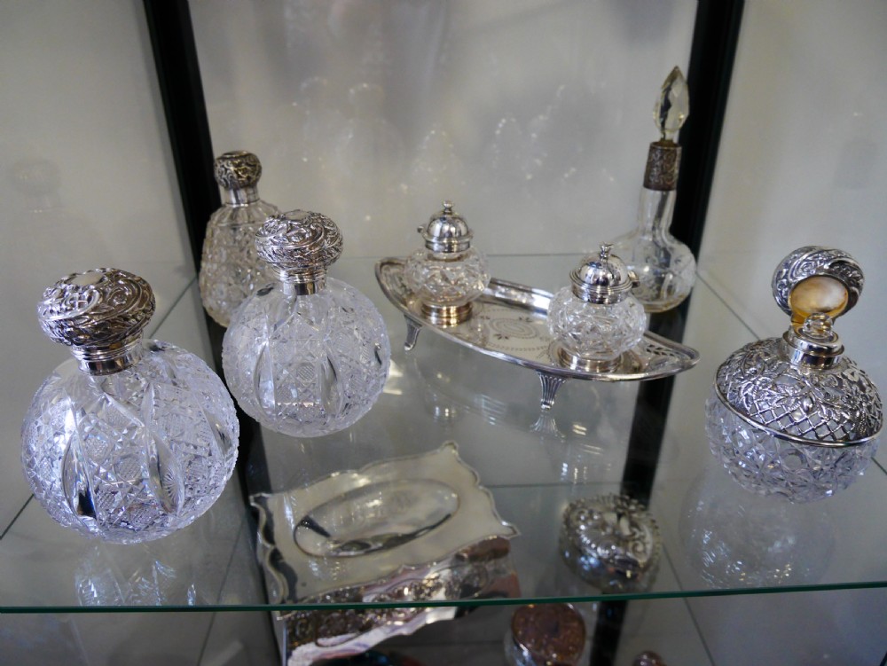 A solid silver boat-shaped tray with pierced scrollwork edges and central engraving, holding two faceted cut-glass inkwells with silver caps. View VI