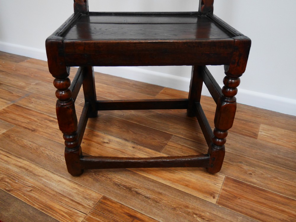 Pair of 17th-century dark oak Derbyshire side chairs featuring arcaded back rails with turned finials and solid wood panel seats. View II