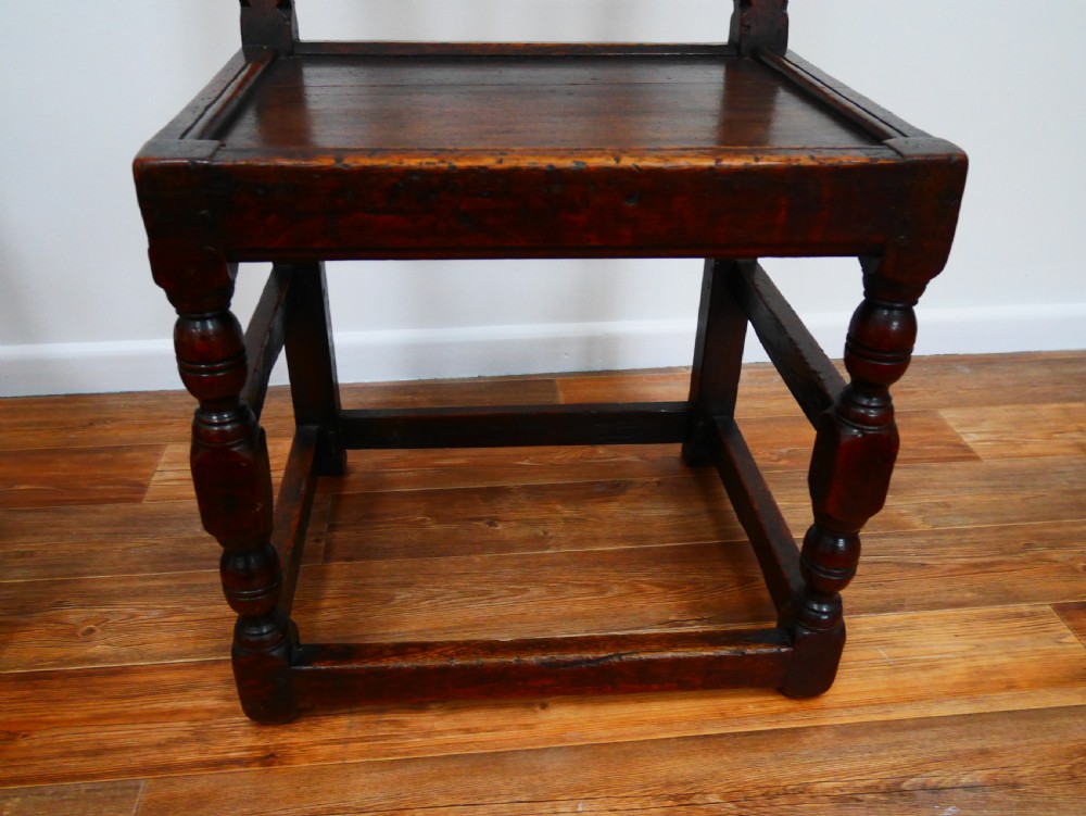 Pair of 17th-century dark oak Derbyshire side chairs featuring arcaded back rails with turned finials and solid wood panel seats. View III