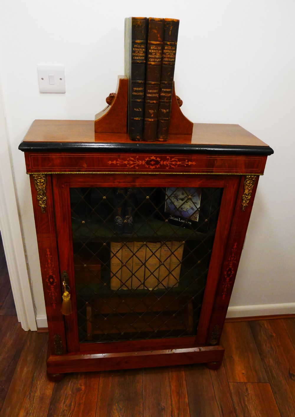 A nineteenth-century Victorian rosewood pier cabinet with a single glazed door, brass lattice detailing, floral marquetry inlay, and gilt brass mounts.