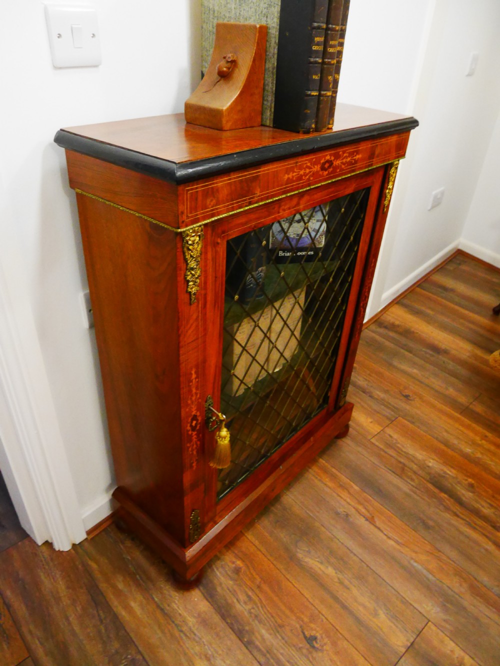 A nineteenth-century Victorian rosewood pier cabinet with a single glazed door, brass lattice detailing, floral marquetry inlay, and gilt brass mounts. View IV