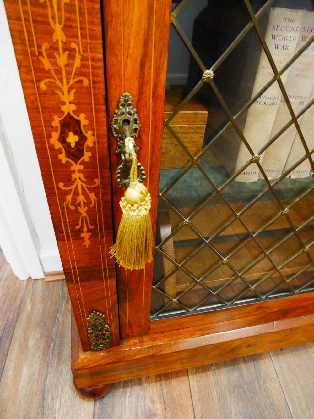 A nineteenth-century Victorian rosewood pier cabinet with a single glazed door, brass lattice detailing, floral marquetry inlay, and gilt brass mounts. View V