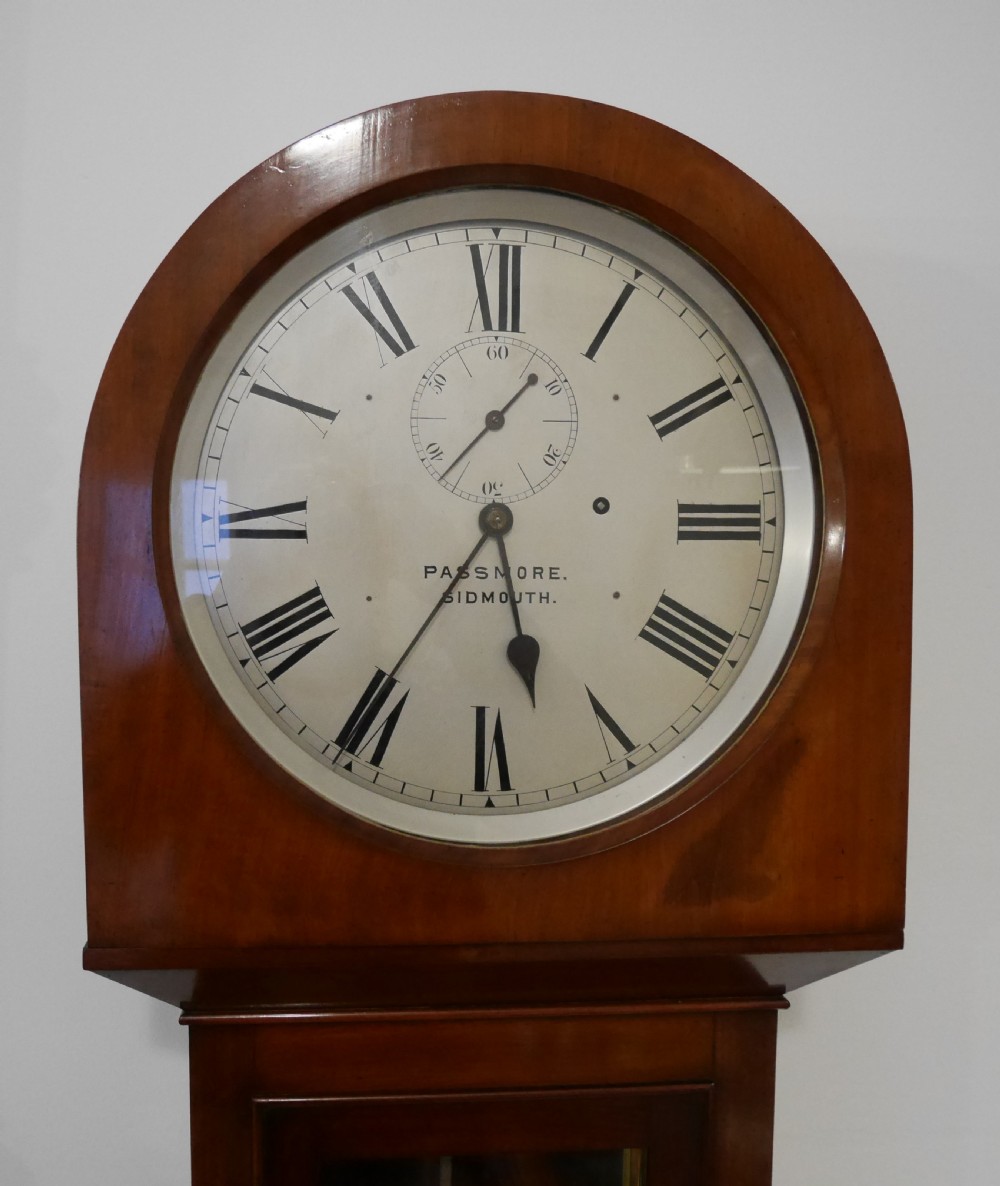 A Victorian mahogany regulator longcase clock featuring an arched hood, a circular white dial with Roman numerals, and a glazed trunk displaying the pendulum mechanism. View II