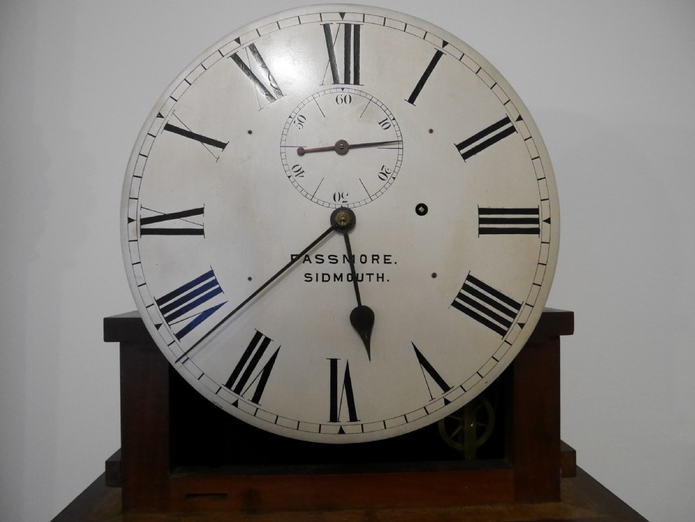 A Victorian mahogany regulator longcase clock featuring an arched hood, a circular white dial with Roman numerals, and a glazed trunk displaying the pendulum mechanism. View IV