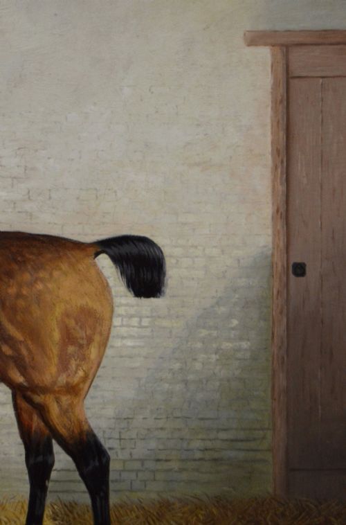 fig 4. A nineteenth-century oil painting featuring a dappled buckskin horse standing in profile inside a stable, framed by a timber surround with a gilt inner slip.