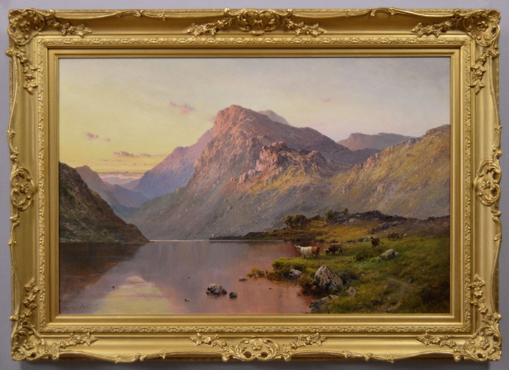 An oil painting of a Scottish loch and mountains at sunset with Highland cattle, framed in an ornate gilded frame.