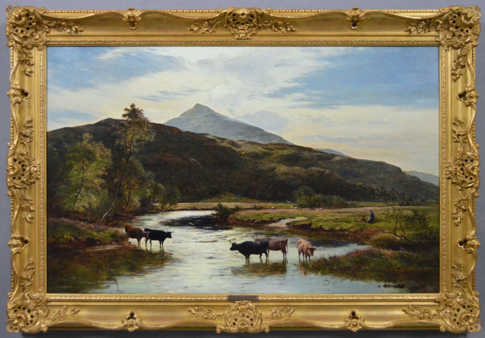 A nineteenth-century landscape oil painting depicting cattle watering in a Welsh mountain river, enclosed within an elaborate carved gold frame.