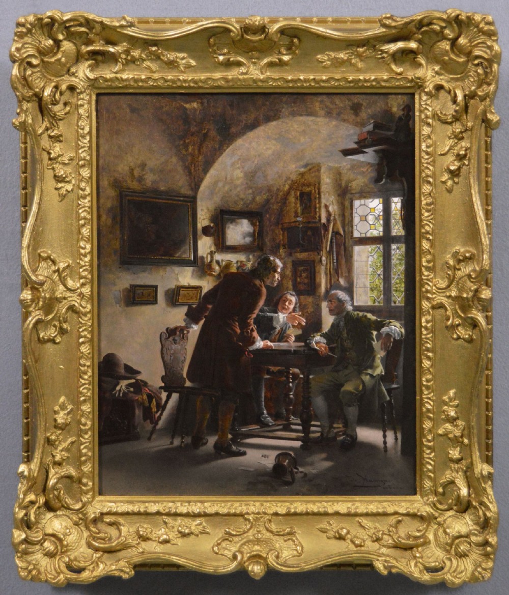 An oil painting depicting three men in 18th-century attire playing cards inside a tavern, framed in an ornate giltwood frame.